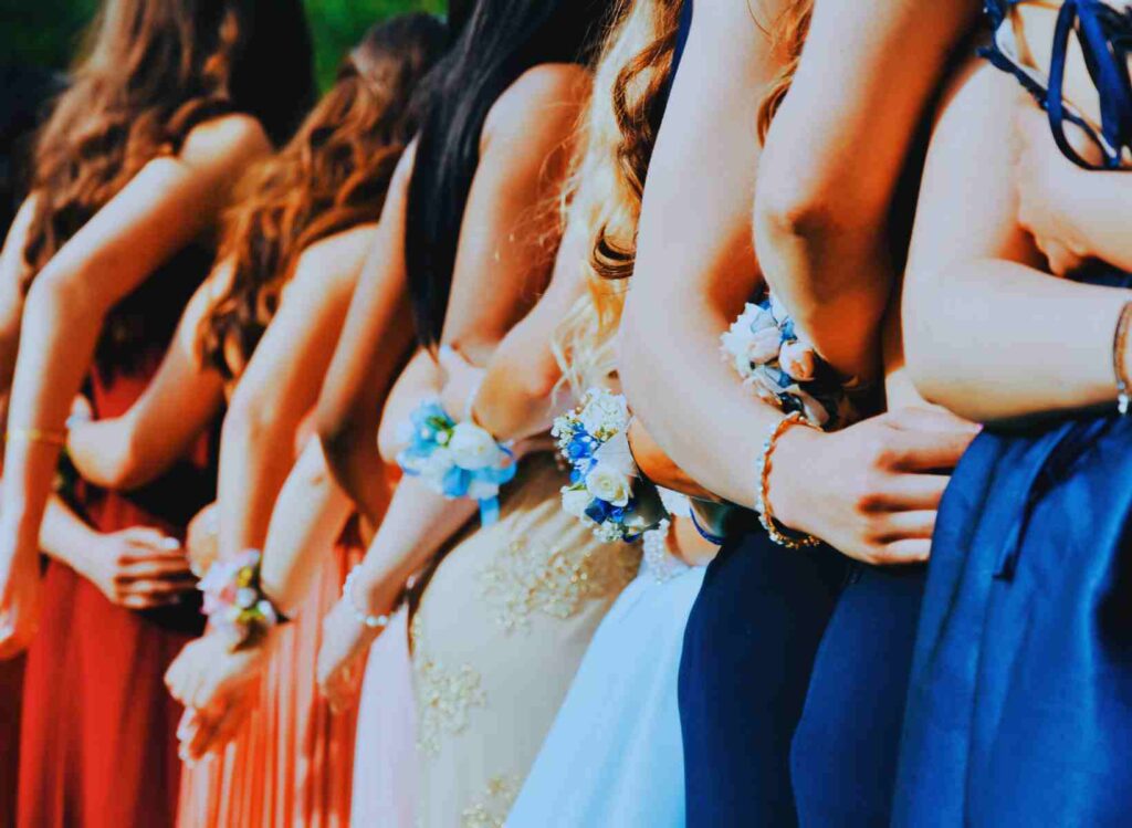 Girls dressed up in evening goes with wrist corsages on prom night